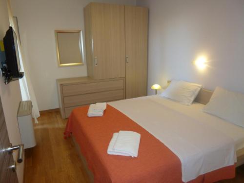 a bedroom with a large bed with two towels on it at Apartments Jukic in Klis