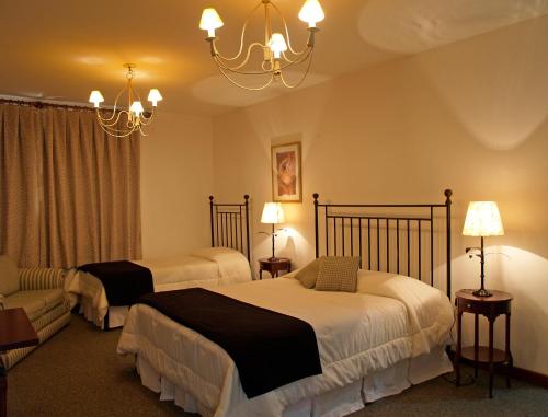 a hotel room with two beds and a chandelier at Don Quixote Pousada in Tiradentes