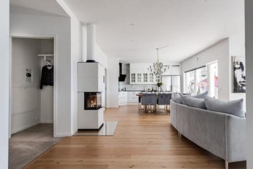 a white living room with a couch and a fireplace at Luxury villa in Kristinehamn