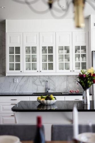 a kitchen with white cabinets and a bowl of fruit at Luxury villa in Kristinehamn