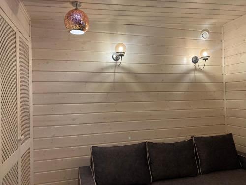 a room with a couch and two lights on a wall at Silumetras in Ventspils