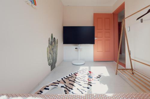 a living room with a red door and a carpet at Chun cheon Bongstay 2nd Floor in Chuncheon