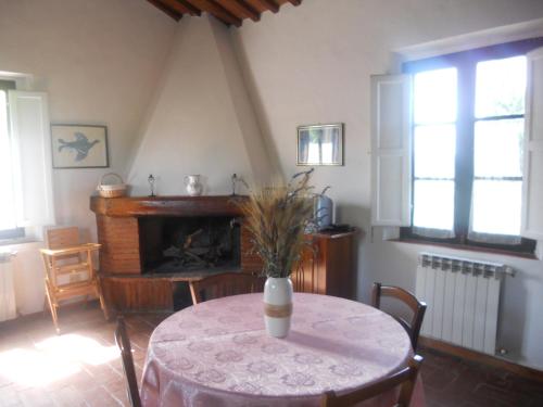 a table with a vase on it in a room with a fireplace at Tenuta Il Tresto in Poggibonsi