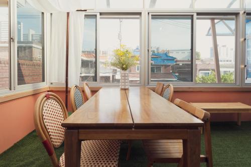 a dining room table with chairs and a vase with flowers at Chun cheon Bongstay 2nd Floor in Chuncheon