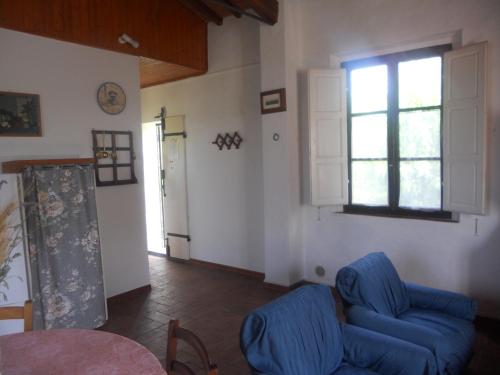 a living room with a blue couch and a window at Tenuta Il Tresto in Poggibonsi