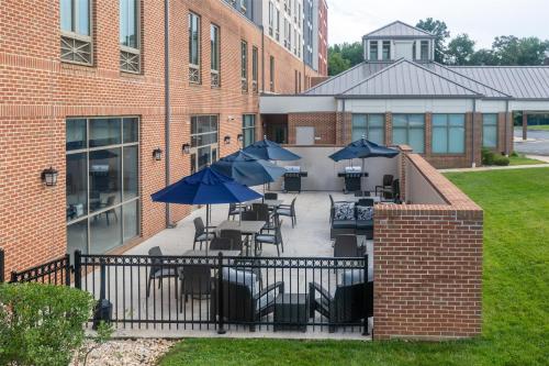 a patio with tables and chairs with umbrellas at Homewood Suites by Hilton Baltimore - Arundel Mills in Hanover