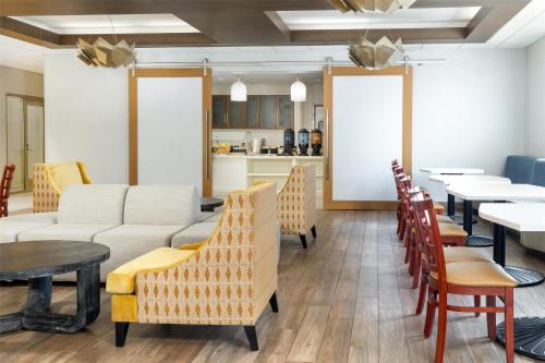 a dining room with couches and tables and chairs at Homewood Suites by Hilton Baltimore - Arundel Mills in Hanover