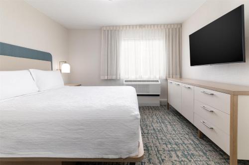 a hotel room with a bed and a flat screen tv at Homewood Suites by Hilton Baltimore - Arundel Mills in Hanover