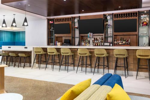 a bar in a restaurant with stools and a counter at Hilton Garden Inn Hanover Arundel Mills, MD in Hanover