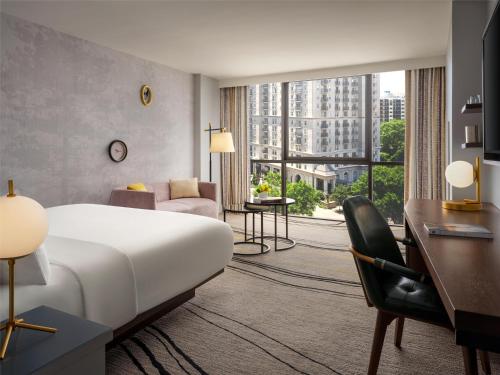 a hotel room with a large bed and a desk at The Starling Atlanta Midtown, Curio Collection by Hilton in Atlanta