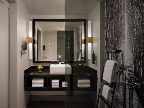 a bathroom with a sink and a mirror at The Starling Atlanta Midtown, Curio Collection by Hilton in Atlanta