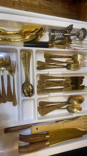 a white tray filled with gold utensils at Silumetras in Ventspils
