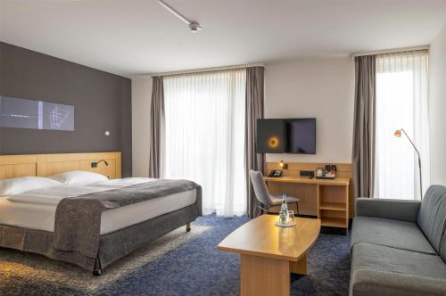 a hotel room with a bed and a couch at Best Western Plus Hotel Papenburg in Papenburg