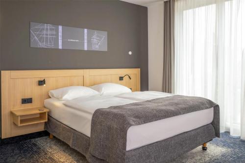 a bedroom with a large bed with white pillows at Best Western Plus Hotel Papenburg in Papenburg