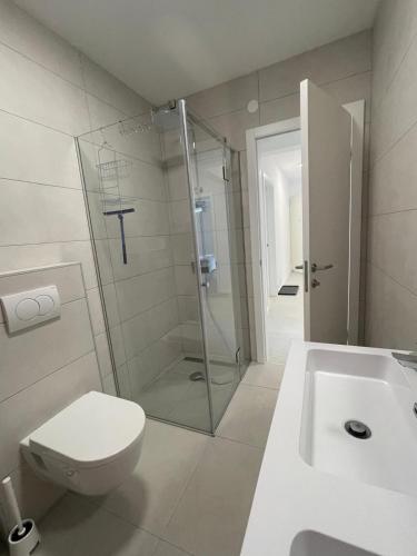 a bathroom with a shower and a toilet and a sink at Villa Una in Crikvenica