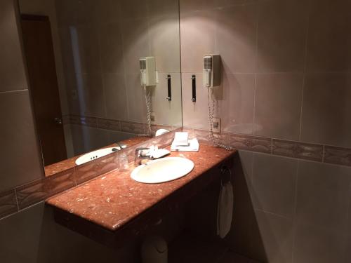 a bathroom with two sinks and a large mirror at Crystal Palace Hotel in Montevideo