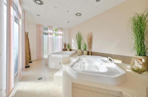 a large bathroom with a large tub and a sink at Best Western Plus Hotel Papenburg in Papenburg