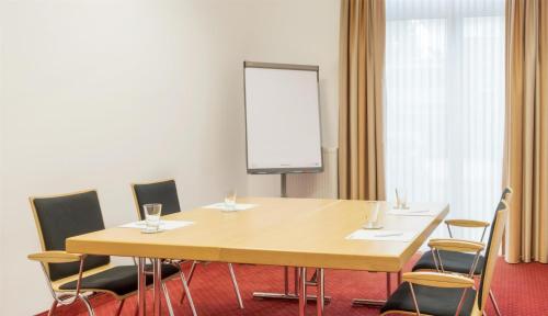 a conference room with a wooden table and chairs at Best Western Plus Hotel Papenburg in Papenburg