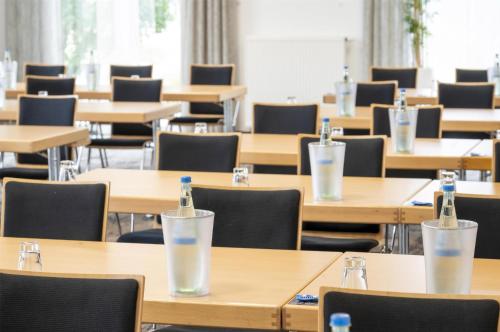 a classroom with tables and chairs with bottles on them at Best Western Plus Hotel Papenburg in Papenburg