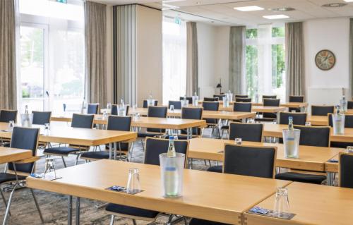 an empty lecture room with tables and chairs at Best Western Plus Hotel Papenburg in Papenburg