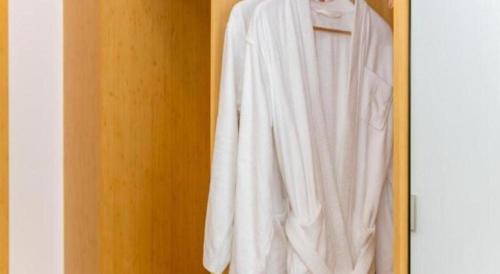 a white shirt hanging on a closet door at GreenTree Inn Qufu High Speed Railway Station in Jining