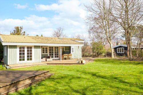 a small white house with a large yard at 12228-Sjaellands-Odde-Strandvaenget-23 in Yderby