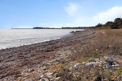 a beach with rocks and the water in the background at 12228-Sjaellands-Odde-Strandvaenget-23 in Yderby