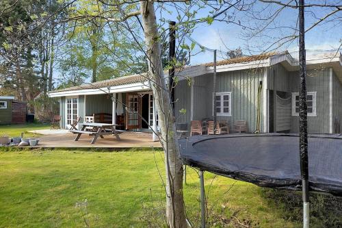 a house with a trampoline in the yard at 12228-Sjaellands-Odde-Strandvaenget-23 in Yderby