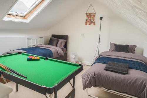 a room with a pool table and two beds at Stunning 5 Bedroom Home in the Heart of Swansea - Snooker Table, WiFi & Parking! in Swansea