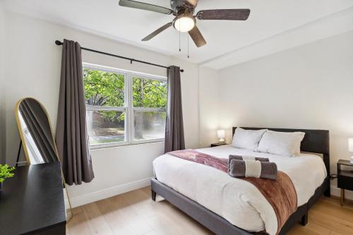 a bedroom with a bed with a ceiling fan and a window at GNV 4 Bed - Stay 4 mins to UF - Family and Alumni in Gainesville