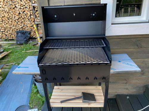 a grill sitting on a table with a pair of tongs at Silumetras in Ventspils
