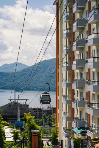 Un edificio de apartamentos con una góndola frente a un lago. en Hotel Mystic Mountain, Pokhara, en Pokhara
