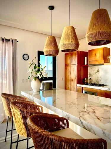 a kitchen with a large marble counter with chairs at Casa del Mar - Luxury Seaside Villa in Boca de la Vinorama