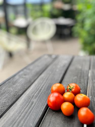 a group of tomatoes sitting on a wooden table at Beautiful house with a charming garden in Brønderslev