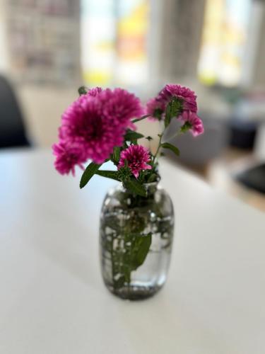 a vase filled with purple flowers sitting on a table at Beautiful house with a charming garden in Brønderslev