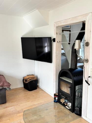 a living room with a fireplace and a flat screen tv at Beautiful house with a charming garden in Brønderslev