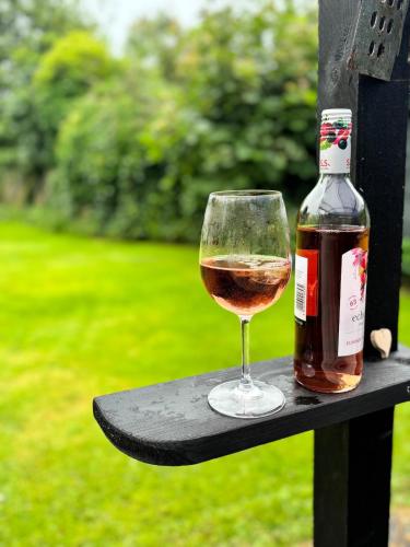 a bottle of wine and a glass on a table at Beautiful house with a charming garden in Brønderslev