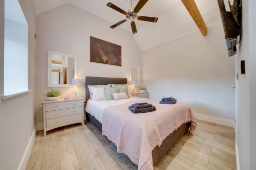 Un dormitorio con una cama y un ventilador de techo. en Quaint converted stables in Carlby, en Carlby