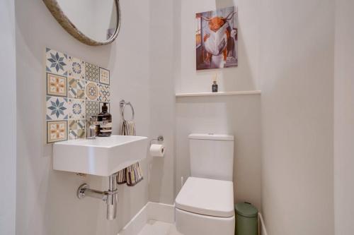 Un baño con un inodoro blanco y un lavabo. en Quaint converted stables in Carlby, en Carlby