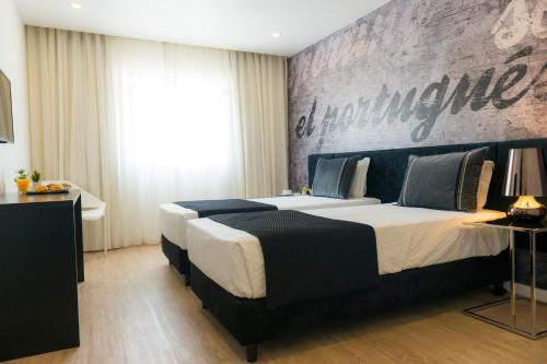 a bedroom with a large bed with a large wall at Sport Hotel A Seleção in Setúbal