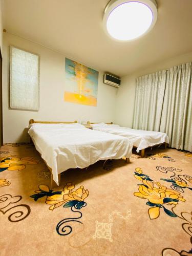 two beds in a room with flowers on the floor at 菜音天然温泉別荘 in Tsu