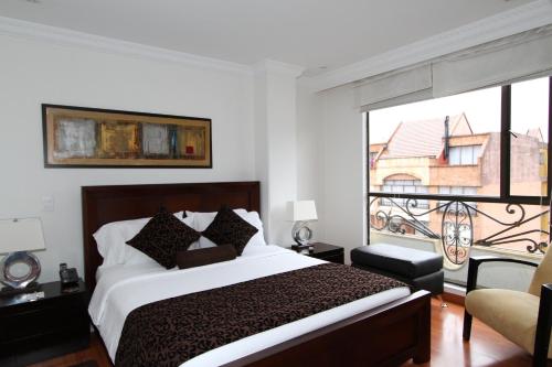 a bedroom with a bed and a large window at Hotel Suites 108 in Bogotá