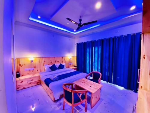 a bedroom with a bed and a wooden table in it at Hotel The SSB - Property of the Year ! Luxury Balcony Rooms ! Mountain View ! Rooftop Cafe ! Big Parking ! in Mussoorie