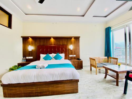 a bedroom with a king sized bed and a desk at Hotel The SSB - Property of the Year ! Luxury Balcony Rooms ! Mountain View ! Rooftop Cafe ! Big Parking ! in Mussoorie