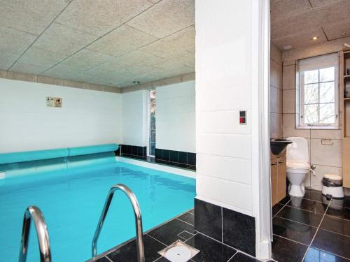 a swimming pool in a bathroom with a toilet at 4 star holiday home in Allingåbro in Nørager