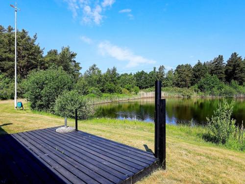 a wooden dock on the side of a lake at 4 person holiday home in Læsø in Læsø