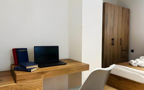 a laptop computer sitting on a desk with books at Rooms Apart Hotel by RED in Yerevan