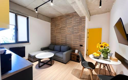 a living room with a couch and a table and chairs at Rooms Apart Hotel by RED in Yerevan