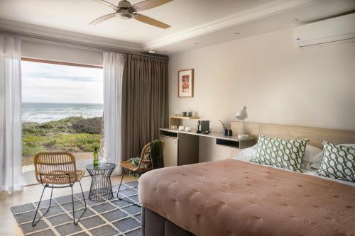 a bedroom with a large bed with a view of the ocean at Paternoster Dunes Boutique Guesthouse in Paternoster