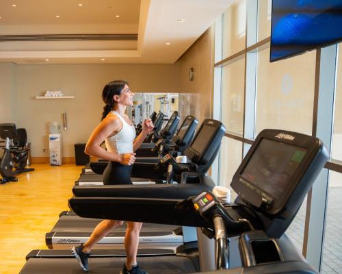 a woman walking on a treadmill in a gym at Marina Hotel in Kuwait